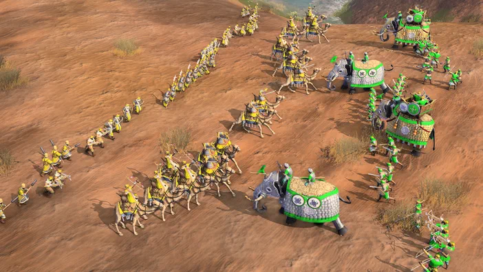 Vue aérienne d'une armée dans Age of Empires IV : Anniversary Edition sur un terrain sablonneux avec des éléphants de guerre et des cavaliers.