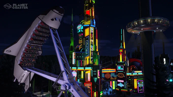 Capture d'écran de Planet Coaster montrant un parc à thème futuriste illuminé la nuit avec des montagnes russes et une tour colorée.