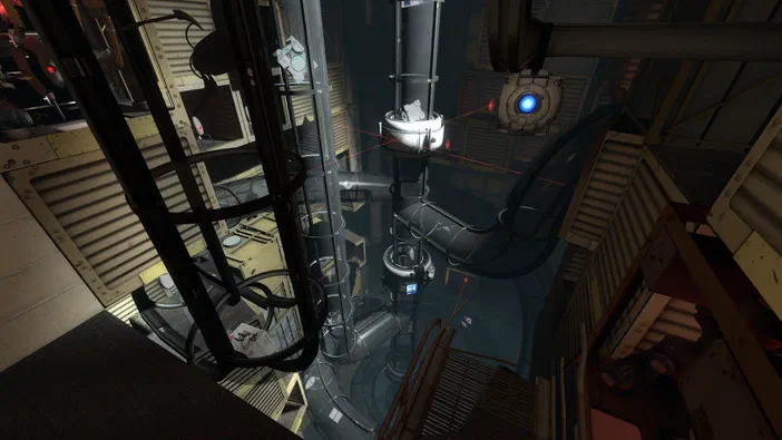 Capture d'écran de Portal 2 montrant une vue en hauteur sur des machines et un cube lumineux dans un environnement industriel.