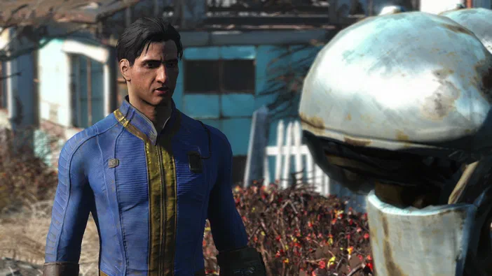 Capture d'écran du jeu Fallout 4 montrant un personnage masculin en combinaison bleue et une tête de robot dans un environnement post-apocalyptique.