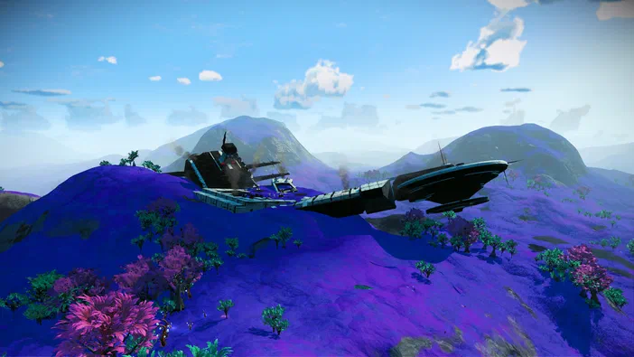 Une épave de cargo flottant au-dessus d'un paysage violet avec des montagnes en arrière-plan dans le jeu No Man's Sky.