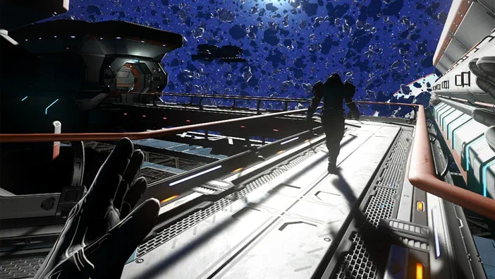 Capture d'écran du jeu vidéo No Man's Sky montrant un personnage marchant sur une plateforme métallique avec des vaisseaux spatiaux et des débris flottants dans le ciel bleu.