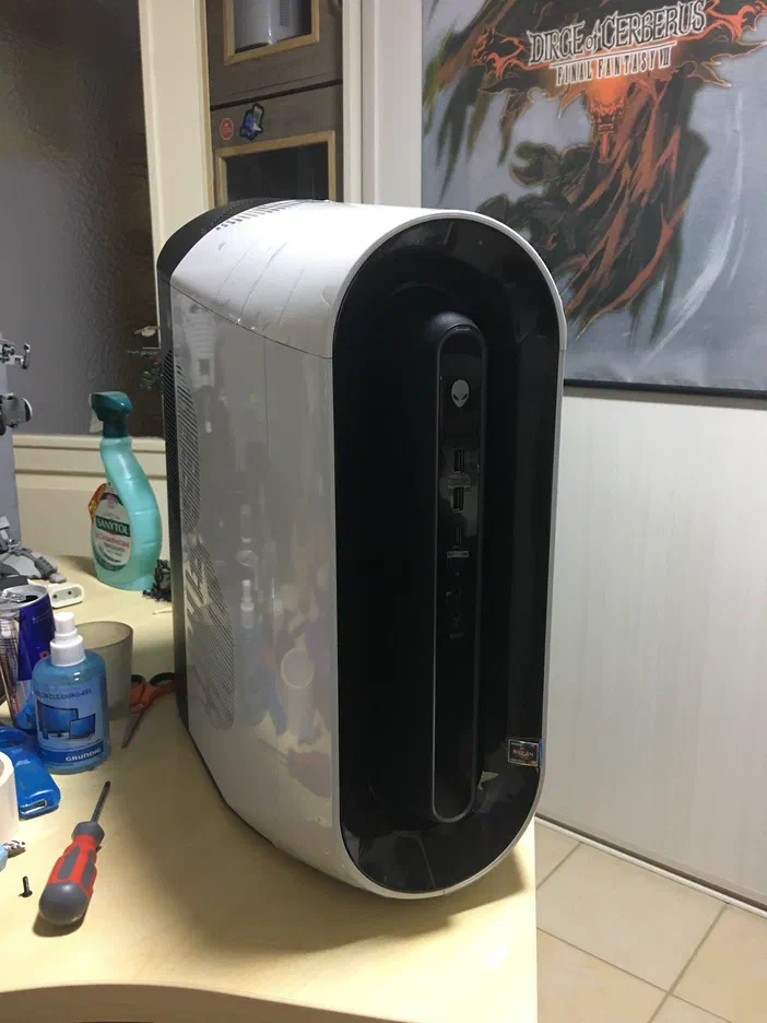Un PC de bureau blanc et noir avec des ports USB sur le panneau avant, posé sur une table en bois.