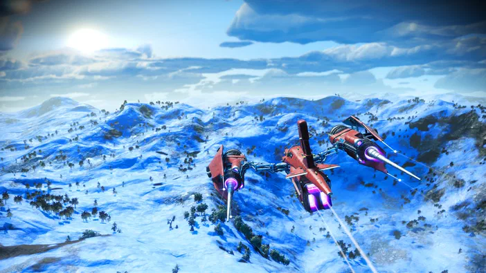 Dans le jeu vidéo No Man's Sky, trois vaisseaux spatiaux rouges survolent un paysage montagneux enneigé sous un ciel bleu parsemé de nuages.