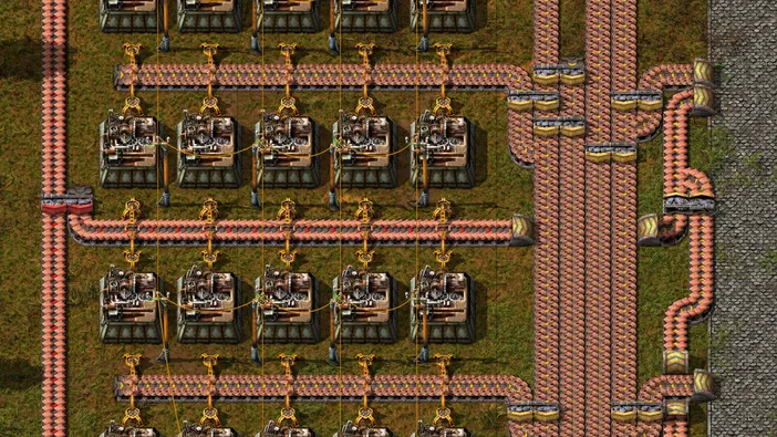Vue de dessus d'une base Factorio avec des convoyeurs et des machines.