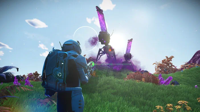 Dans le jeu vidéo No Man's Sky, un personnage en armure bleue observe des structures géantes émettant une lueur violette sur un terrain verdoyant parsemé de fleurs.