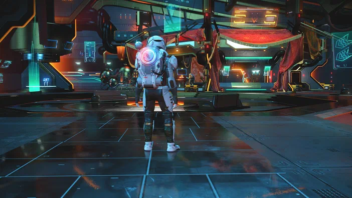 Dans No Man's Sky, un personnage en combinaison spatiale se tient dans une base futuriste aux couleurs néons.
