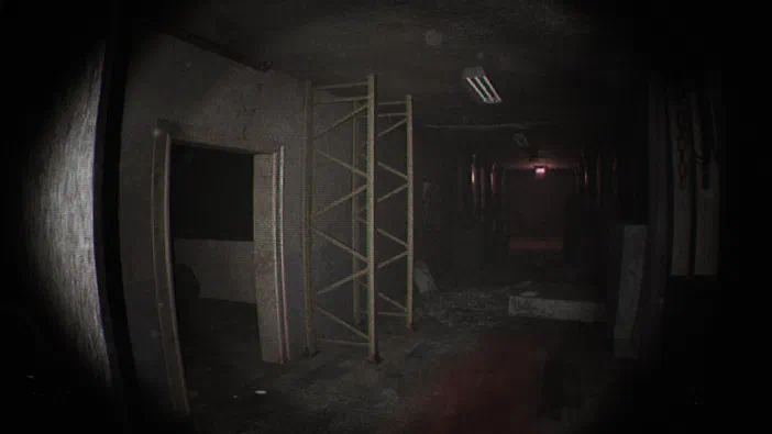 Capture d'écran du jeu Unknown Tapes montrant un couloir sombre et abandonné avec des échafaudages métalliques.