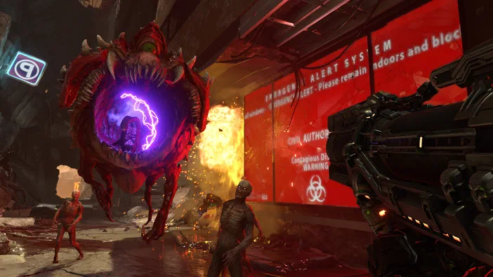 Capture de jeu vidéo DOOM Eternal montrant un monstre rouge géant avec une lueur violette au centre, des ennemis et une arme futuriste dans un environnement industriel en feu.