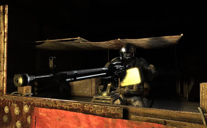 Dans le jeu vidéo Metro 2033, un soldat en armure et casque tient une arme lourde dans un abri sombre.