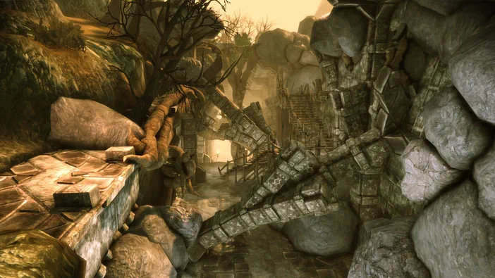 Capture d'écran du jeu vidéo Dragon Age: Origins - Awakening montrant un personnage dans une ruine rocheuse avec des escaliers en bois et de la végétation.
