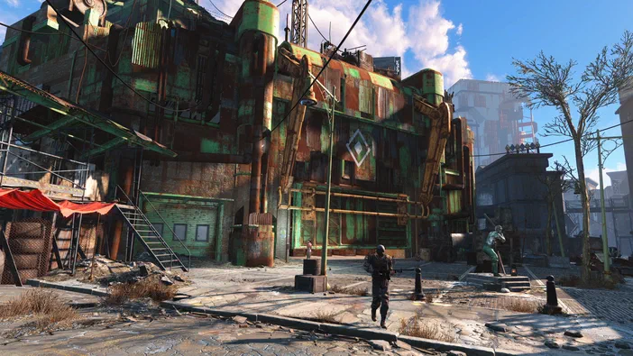 Capture d'écran de Fallout 4 montrant un personnage marchant devant une usine abandonnée aux murs rouillés et verts dans un environnement post-apocalyptique.
