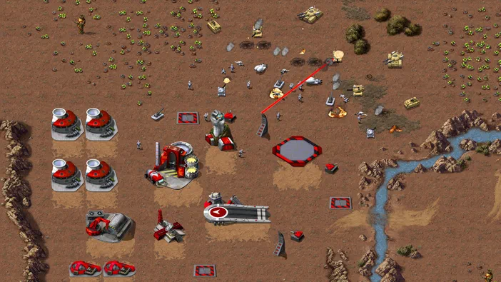 Capture d'écran de Command & Conquer Remastered Collection montrant une base rouge avec des unités et véhicules sur un terrain désertique.