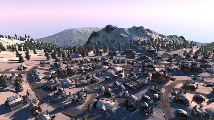 Vue aérienne d'une ville de jeu Cities XL Platinum enneigée avec des maisons et forêts au pied de montagnes.