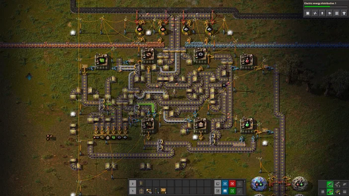 Capture d'écran du jeu de stratégie Factorio montrant une usine complexe avec des tuyaux et machines.