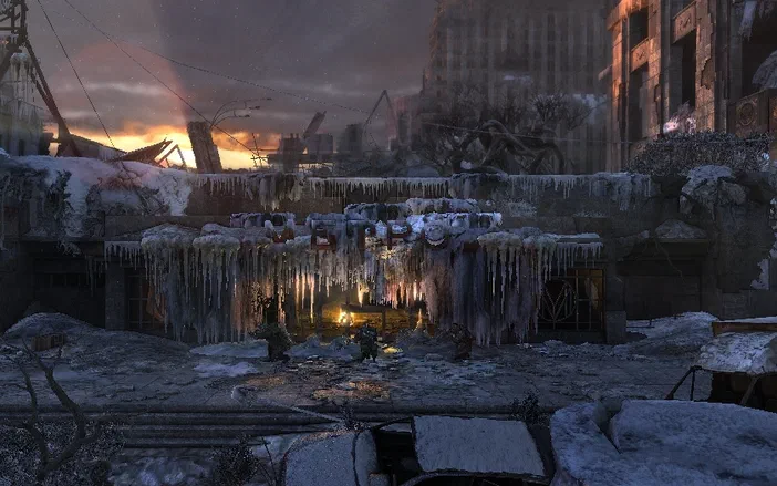 Capture d'écran du jeu vidéo Metro 2033 montrant un paysage post-apocalyptique enneigé avec des bâtiments en ruine et une lumière orangée au loin.