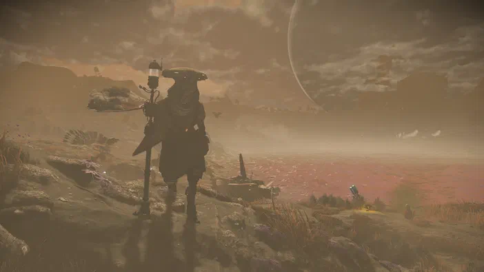 Capture d'écran du jeu vidéo No Man's Sky montrant un personnage en armure debout sur une planète désertique avec des rochers et une lune visible dans le ciel.