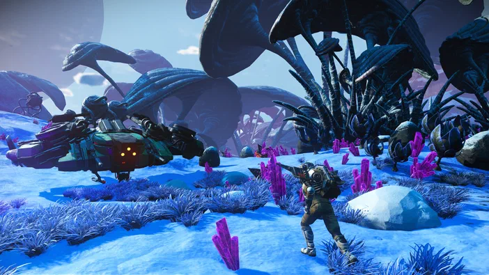 Dans le jeu vidéo No Man's Sky, un personnage en armure se tient sur une planète aux cristaux violets et à la végétation bleue, avec des vaisseaux spatiaux au loin.
