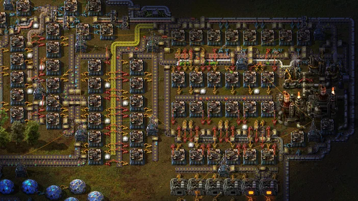 Vue d'une base industrielle complexe dans le jeu Factorio avec des usines et des lignes de transport.