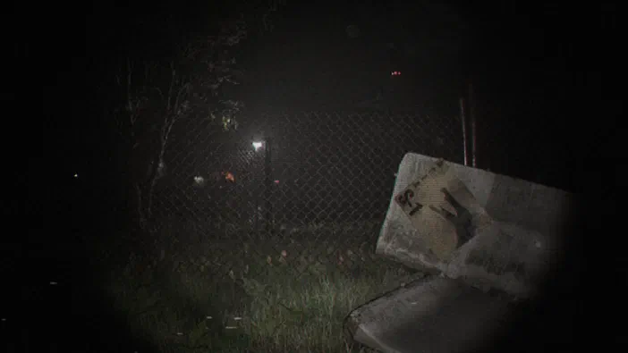 Capture d'écran du jeu Unknown Tapes montrant une scène nocturne avec un banc en bois et une clôture grillagée.