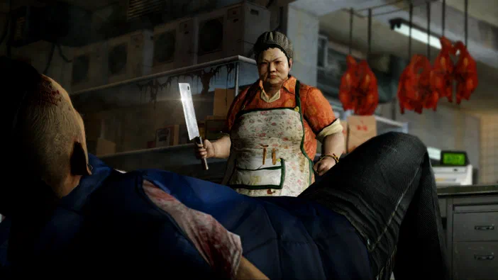Dans le jeu Sleeping Dogs™, une femme tenant un couteau menace un homme allongé dans ce qui semble être un abattoir.