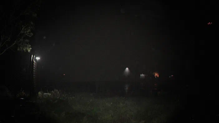 Capture d'écran du jeu vidéo Unknown Tapes montrant une scène nocturne sombre avec quelques lumières lointaines et un lampadaire à gauche.
