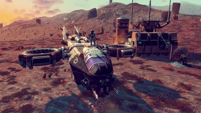 Capture d'écran du jeu vidéo No Man's Sky montrant un vaisseau spatial futuriste posé sur une planète désertique avec des structures industrielles en arrière-plan.