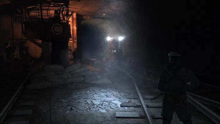 Dans le jeu vidéo Metro 2033, un personnage se tient dans une gare souterraine sombre avec des rails et du matériel ferroviaire.