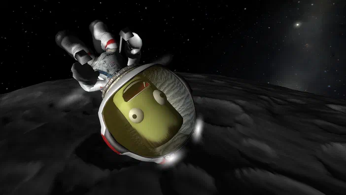 Dans Kerbal Space Program, un astronaute jaune aux yeux ronds flotte dans l'espace au-dessus d'un astéroïde sombre parsemé de cratères.