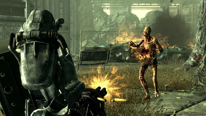 Dans Fallout 3 - Game of the Year Edition, un joueur en armure T-60 vise une créature zombie dans une zone post-apocalyptique.