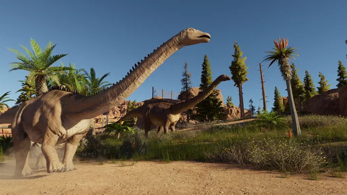 Deux Diplodocus dans un enclos du Montana, avec des palmiers et des conifères en arrière-plan.