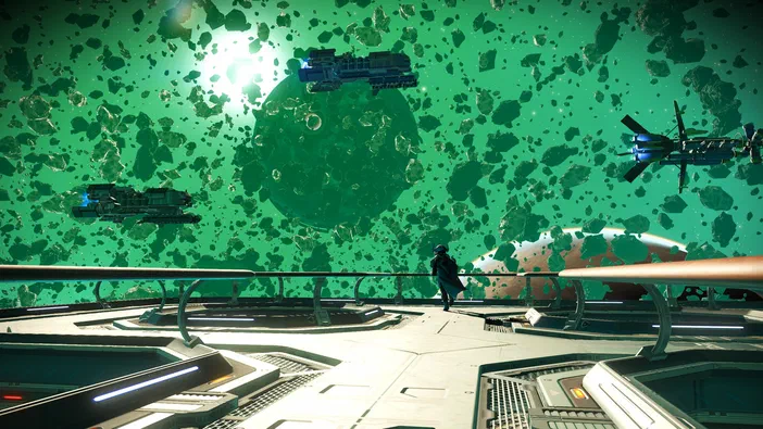 Capture d'écran du jeu vidéo No Man's Sky montrant un vaisseau spatial sur une plateforme observatoire face à un champ d'astéroïdes verts et des autres navires.