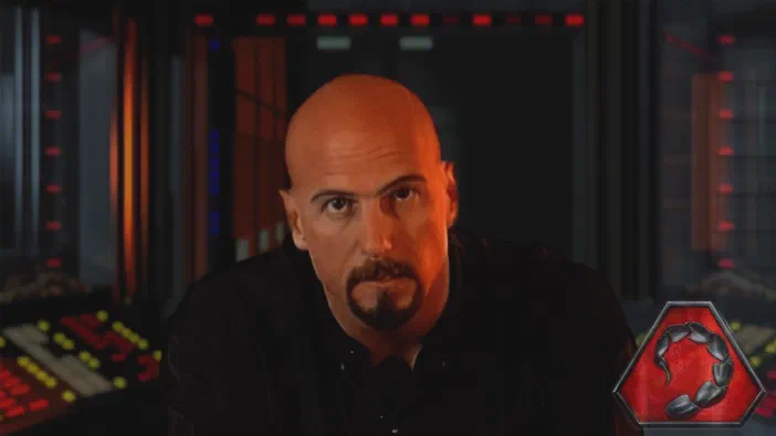 Command & Conquer™ Remastered Collection : un personnage chauve à la barbe dans une base militaire avec des panneaux de contrôle et le logo du jeu en bas.