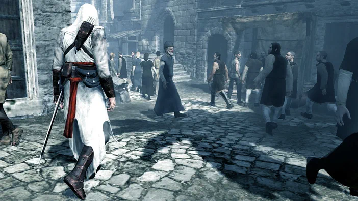 Capture d'écran du jeu vidéo Assassin's Creed montrant un personnage en tenue blanche marchant dans une rue pavée entouré de plusieurs autres personnages vêtus à l'ancienne.