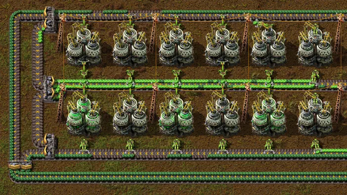 Vue de dessus d'une base Factorio avec des lignes de production et des robots verts.