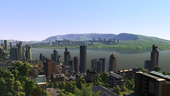 Vue aérienne d'une ville moderne avec des gratte-ciels bordant un large fleuve et des collines en arrière-plan dans Cities XL Platinum.