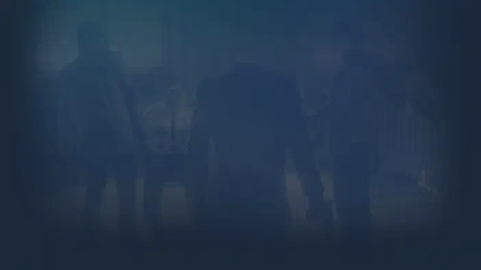 Fond d'écran du jeu Hitman: Absolution montrant une scène sombre et floue avec des silhouettes de personnages.