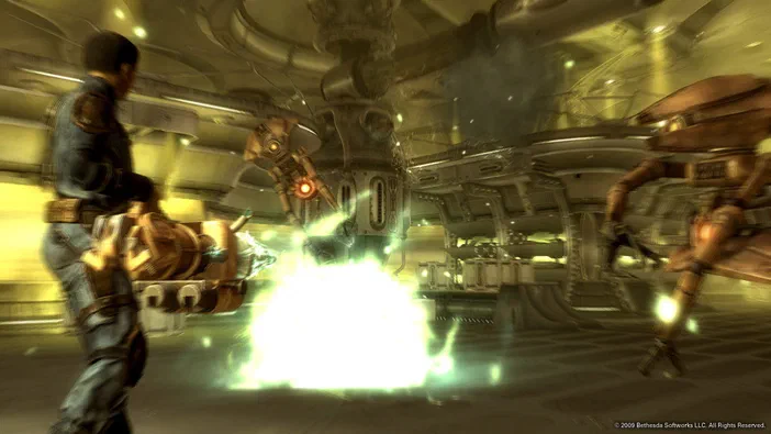 Dans Fallout 3 - Game of the Year Edition, un personnage tire sur des robots dans une base industrielle.