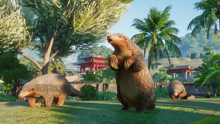 Dans le jeu Planet Zoo, trois pangolins se tiennent sur une pelouse verte avec des arbres et un temple rouge en arrière-plan.