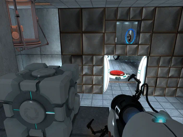 Capture d'écran du jeu vidéo Portal montrant une arme à portal et un cube Aperture Science dans un environnement industriel.