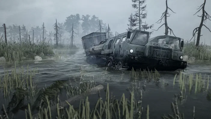 MudRunner : un camion de chantier encastré dans une flaque boueuse au milieu d'une forêt brumeuse