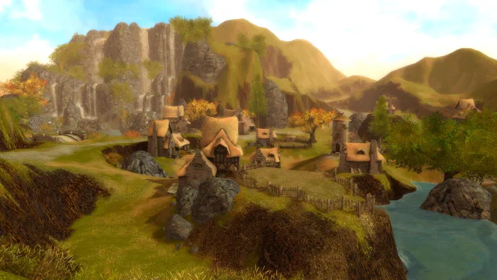 Capture d'écran de Guild Wars® Reforged montrant un village médiéval avec des chaumes entouré de montagnes et une rivière.