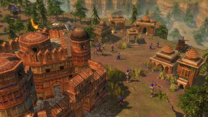 Capture d'écran du jeu vidéo Age of Empires III montrant un village indien avec des bâtiments en briques et des soldats.