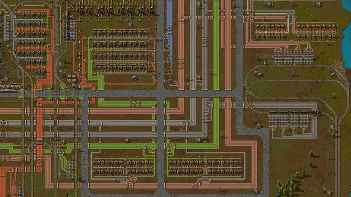 Vue de haut d'une base complexe dans le jeu Factorio avec des lignes de production et des routes.