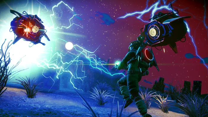Dans le jeu vidéo No Man's Sky, un personnage en armure se tient sur une planète désertique sous un ciel étoilé rouge et bleu. Deux vaisseaux spatiaux flottent de part et d'autre du champ visuel, émettant des éclairs lumineux bleus qui traversent l'atmosphère.