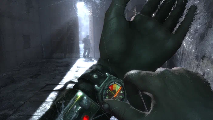 Dans le jeu vidéo Metro 2033, une vue en première personne montre un personnage tenant son poignet avec un appareil de mesure dans un couloir sombre et délabré.