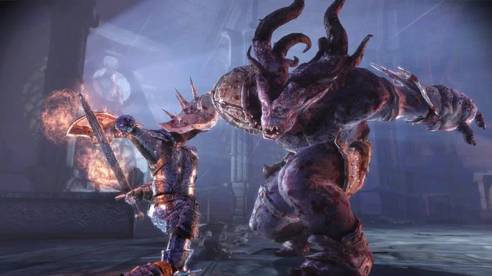 Dans le jeu vidéo Dragon Age: Origins, un personnage en armure lance une attaque magique contre un monstre géant à la peau coriace dans un décor sombre.