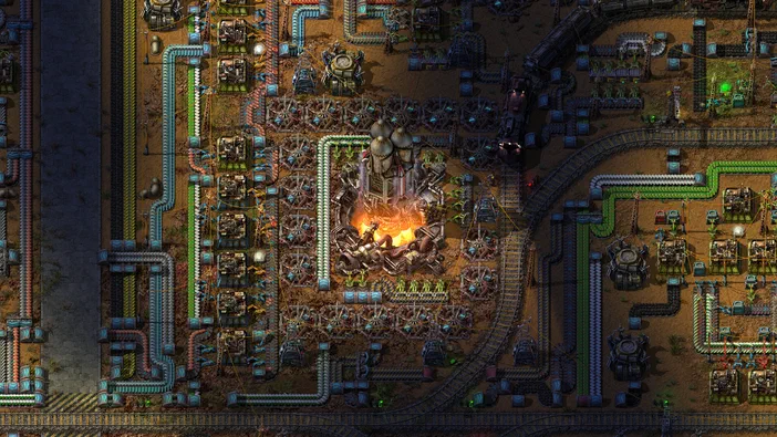 Vue de dessus d'une base industrielle complexe dans le jeu Factorio avec des usines et des trains.