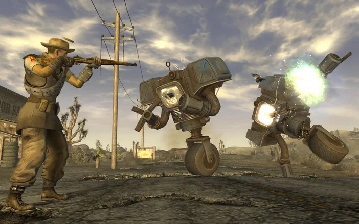 Dans Fallout: New Vegas, un soldat vise avec une carabine face à deux robots bipèdes en combat dans un désert post-apocalyptique.