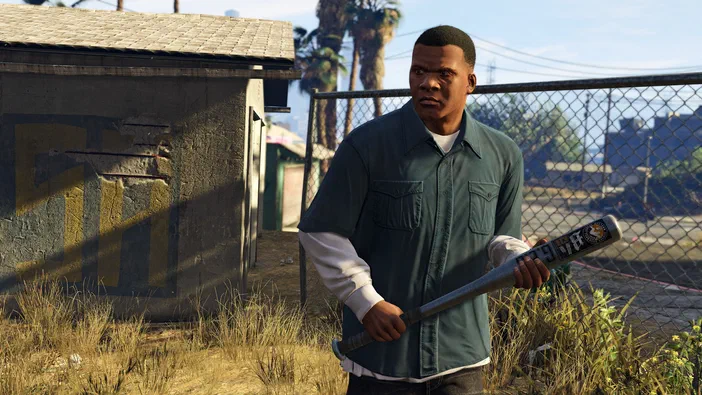 Dans Grand Theft Auto V Legacy, un personnage noir tient une batte de baseball devant une clôture et des palmiers.